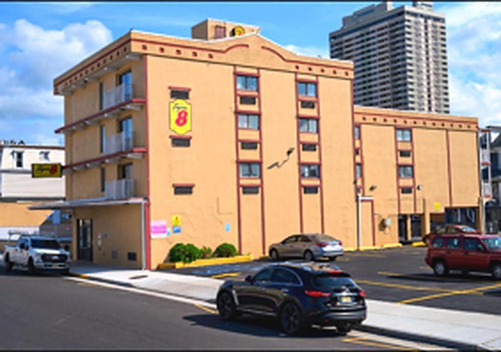 a building with cars parked in front of a street at Super 8 by Wyndham Atlantic City in Atlantic City