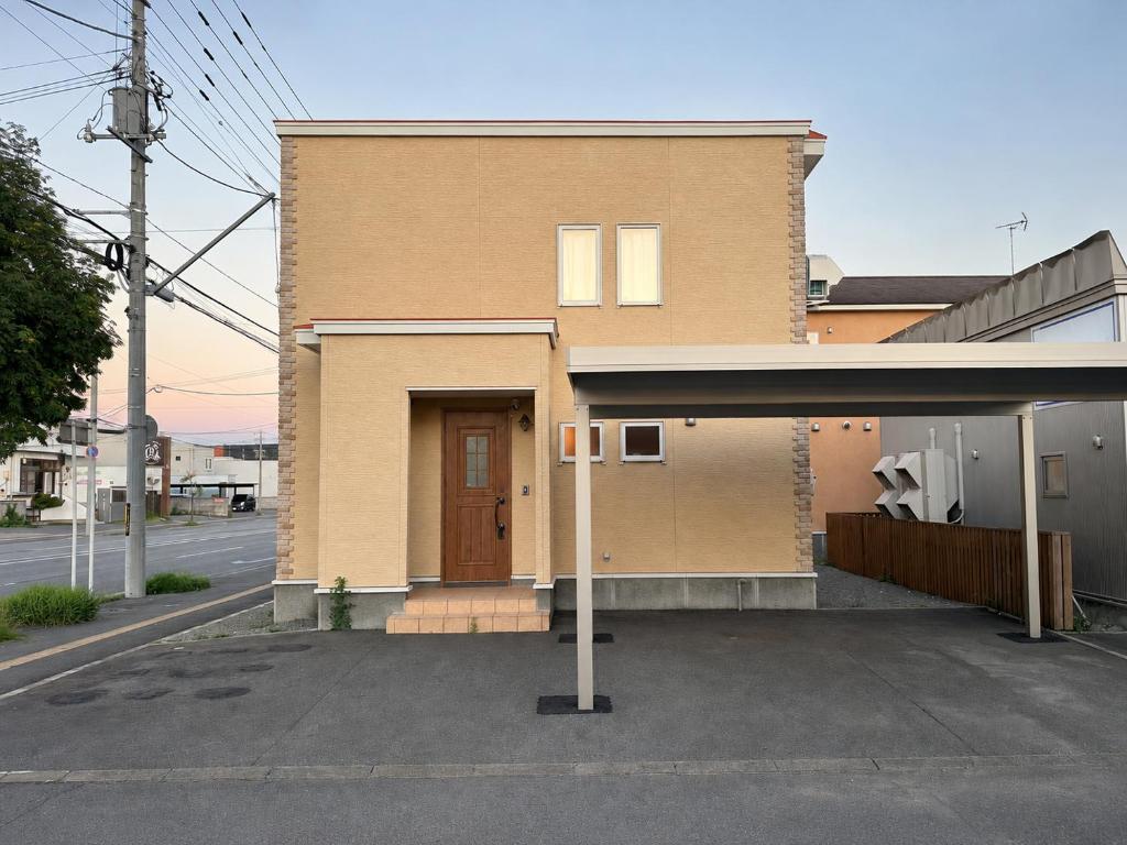 a brown house with a brown door on a street at Akatsuki Villa 暁 in Asahikawa