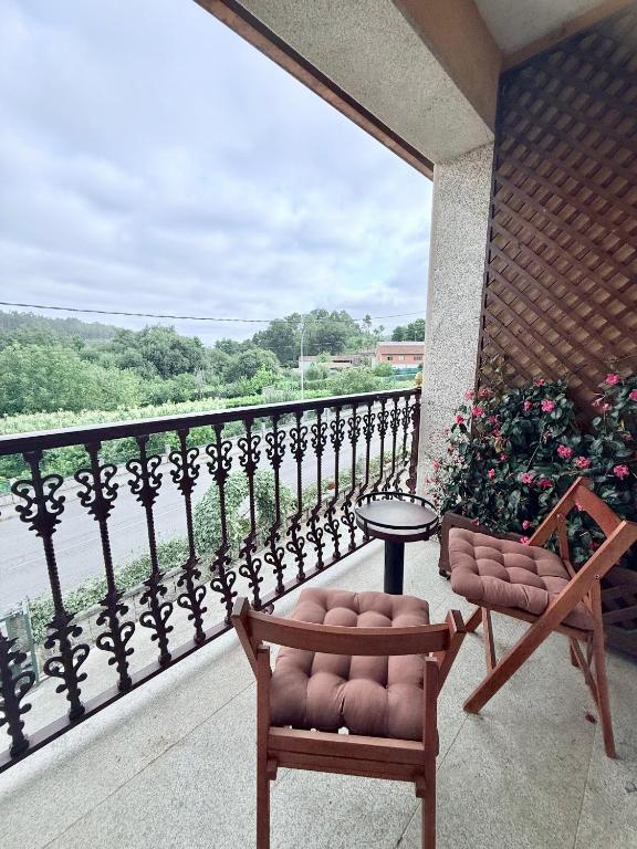 a balcony with a table and two chairs and a view at Casa Romai Portas in Romay