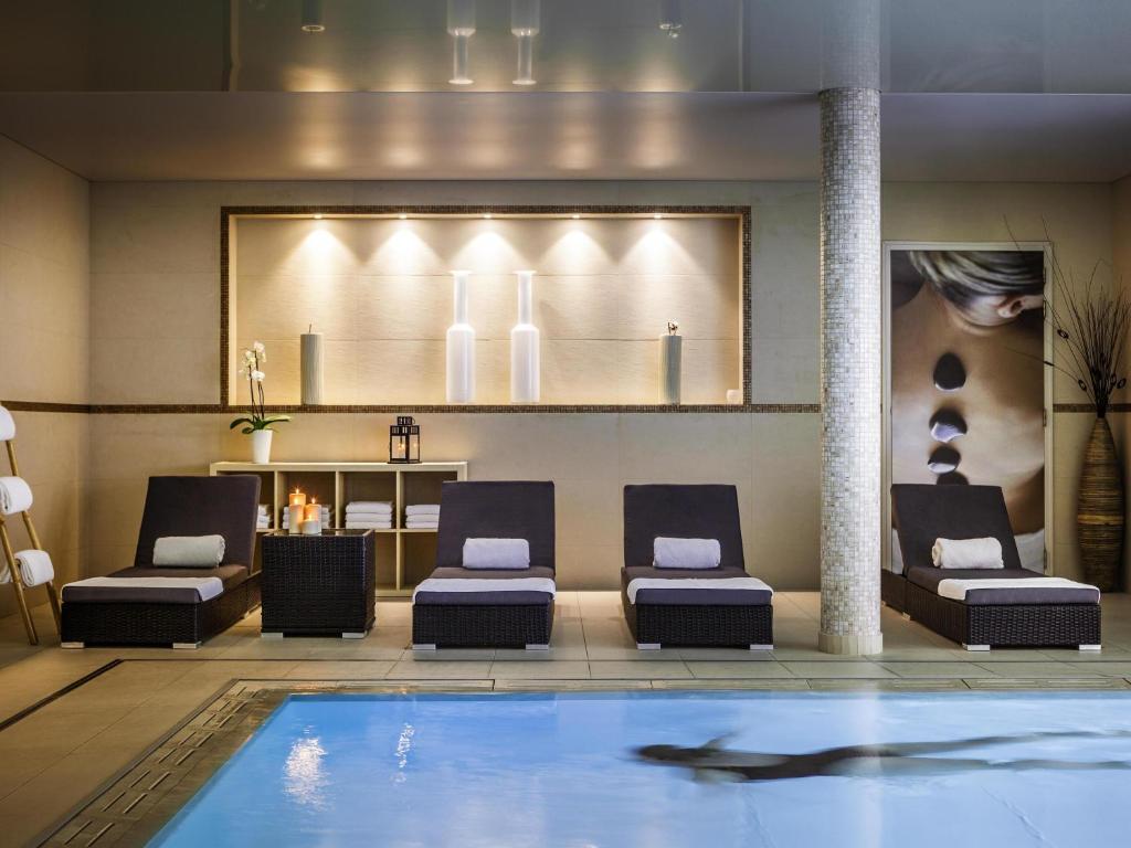 a swimming pool in a hotel lobby with a shark in the water at Novotel SPA Rennes Centre Gare in Rennes