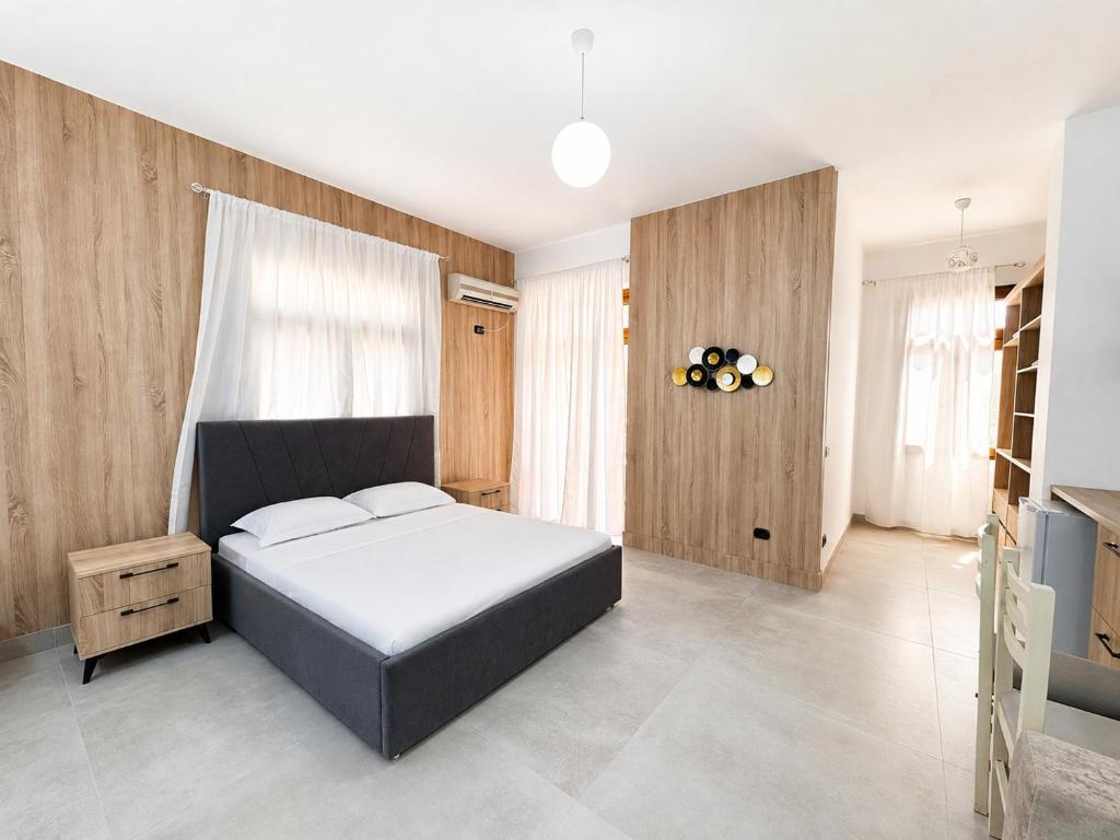 a bedroom with a large bed and wooden walls at Hotel Mjeshtri in Shëngjin