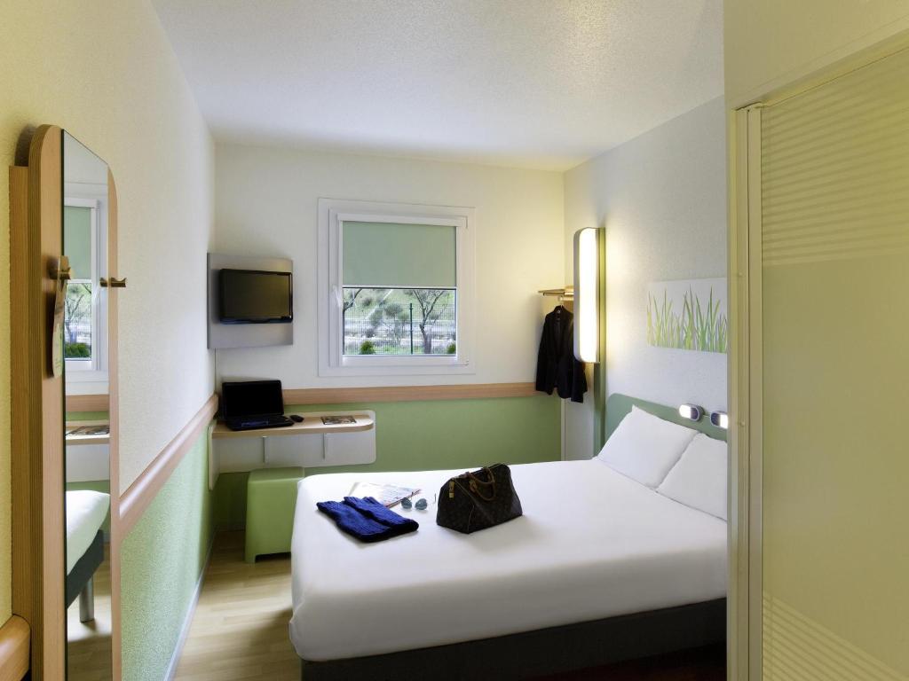 a hotel room with a white bed and a window at Ibis Budget Madrid Getafe in Getafe