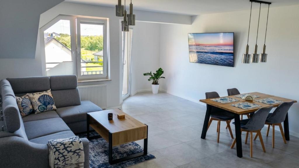 a living room with a couch and a table at Apartament C22 in Darłowo