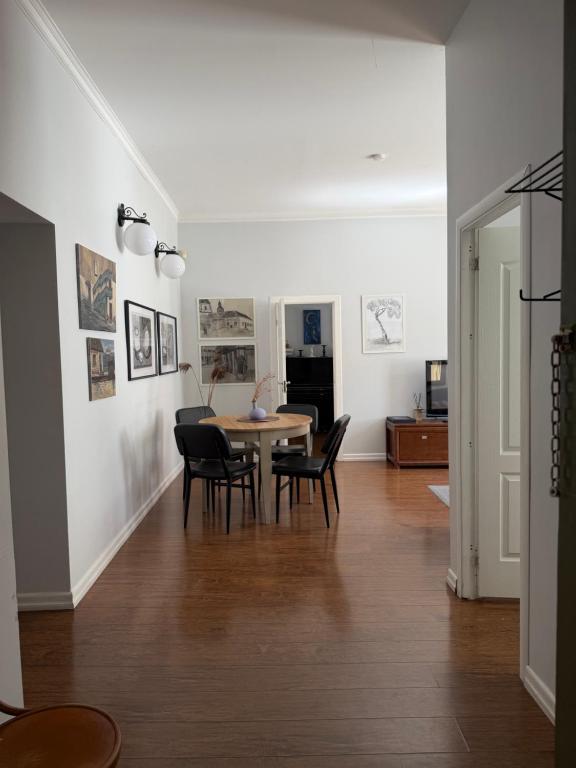 a dining room and living room with a table and chairs at Maironis - Spacious Apartment in the Heart of Kaunas in Kaunas