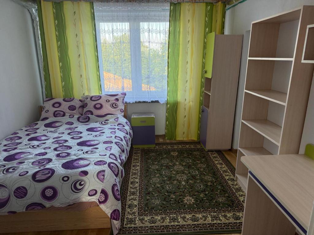 a bedroom with a bed and a window with green curtains at Cosy accommodation in Dańce
