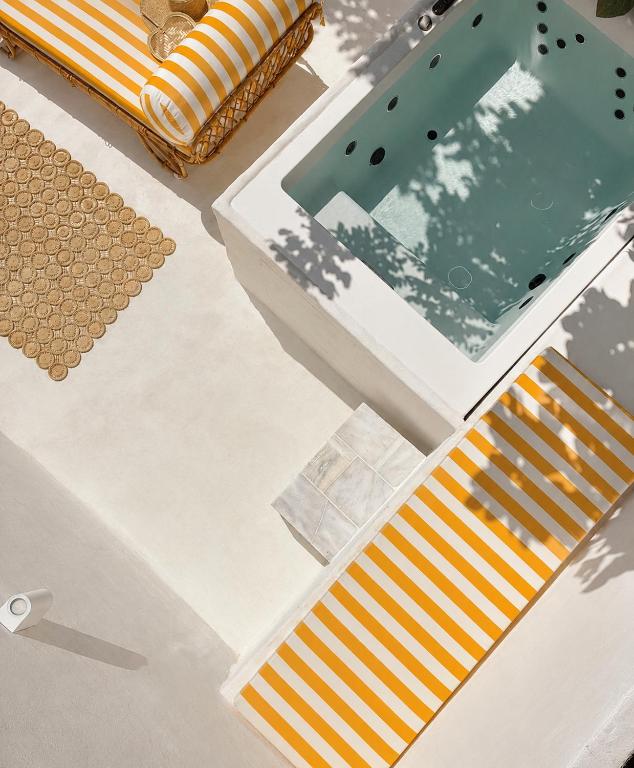 a table with orange and white cushions and a mirror at THE HILL Suite in Ialysos