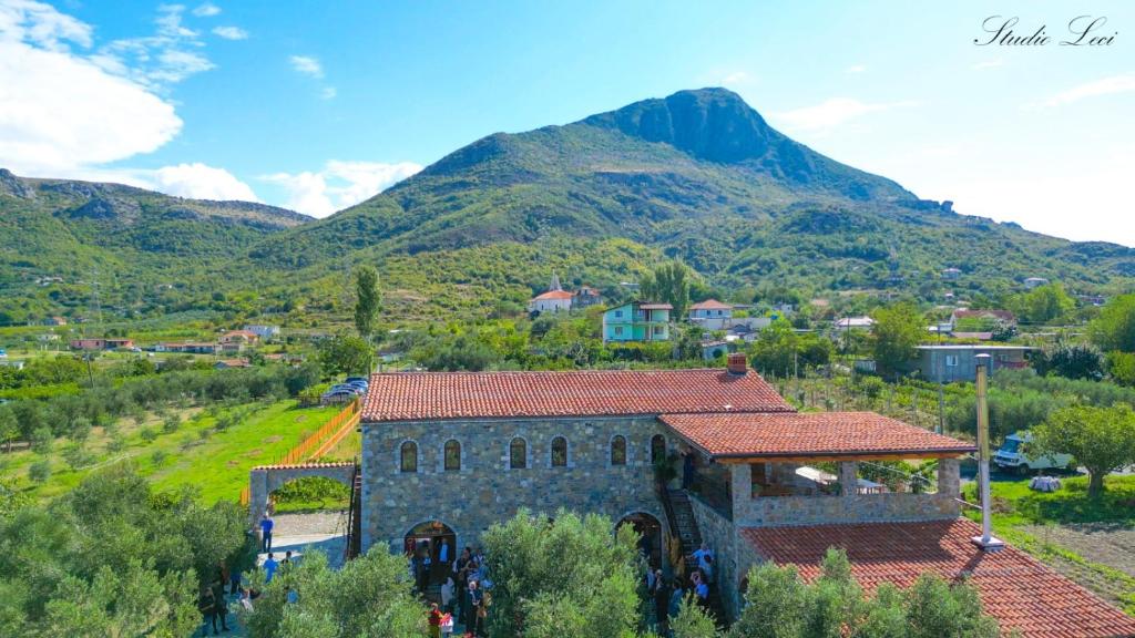 a stone building with a mountain in the background at Kulla Zefit Agritourism in Hajmel