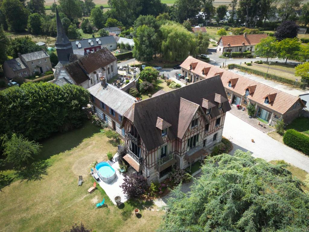 an aerial view of a large house with a pool at Caux Loc' du Manoir in Graincourt