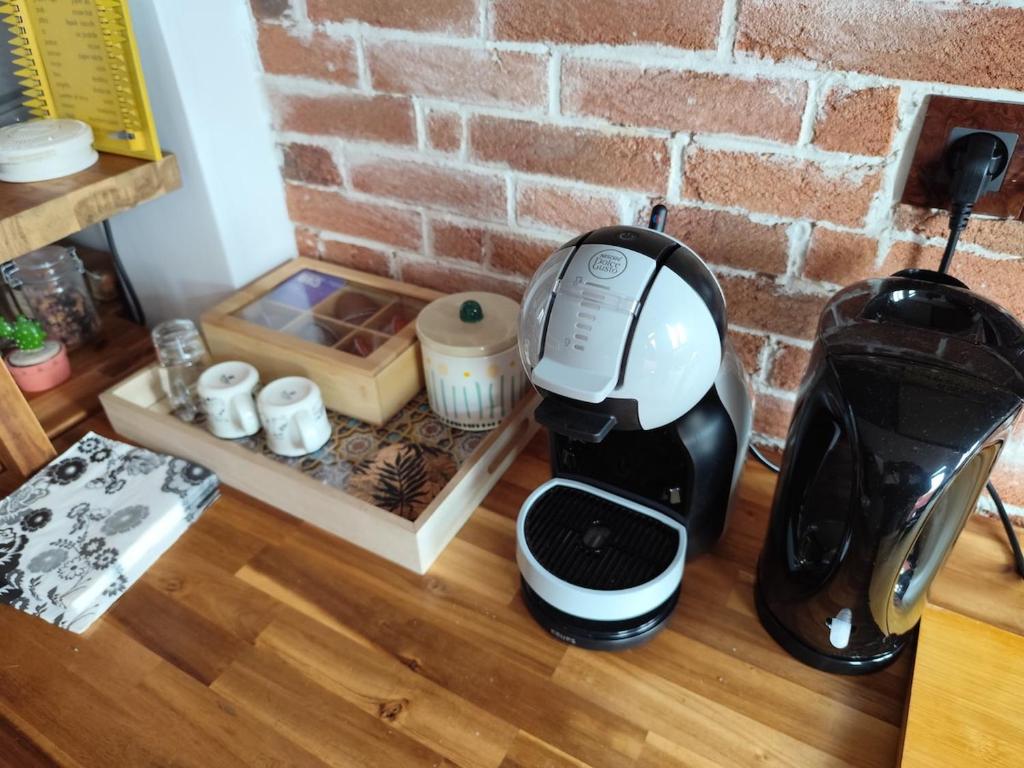 a coffee maker sitting on a counter next to a brick wall at Loft in a quiet condominium in Vitry-sur-Seine