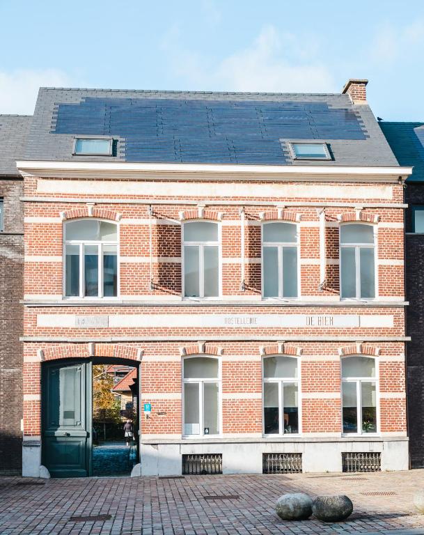 ein rotes Backsteingebäude mit einer grünen Tür in der Unterkunft Hostellerie De Biek in Moorsel