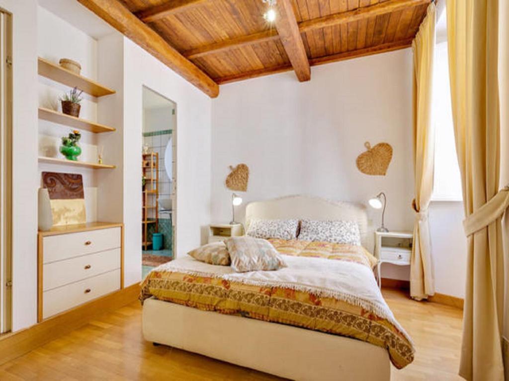ローマにあるIl Mandorlo a Montiの木製の天井のベッドルーム1室(大型ベッド1台付)