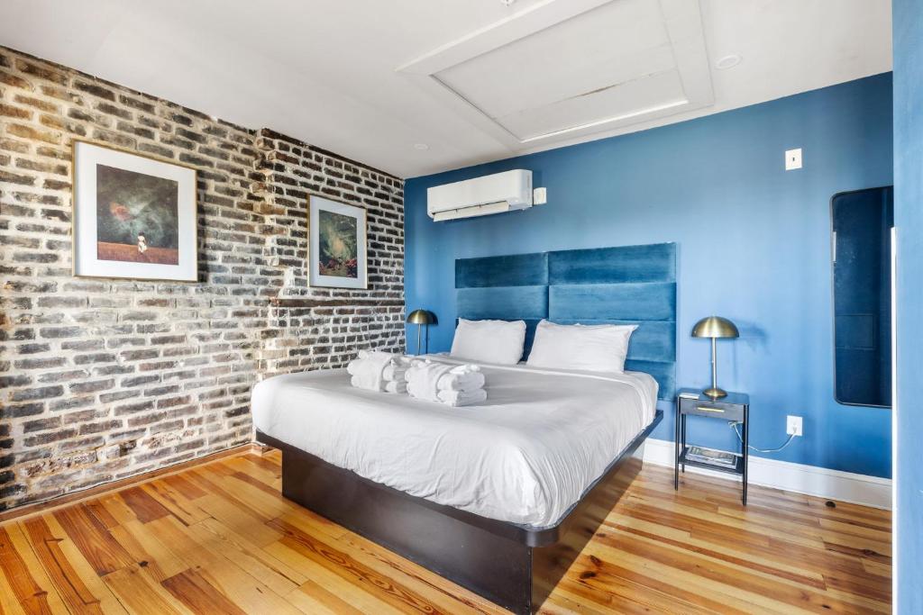 a bedroom with a large bed with a brick wall at King Suite 4th Floor Downtown Hotel Boutique in Savannah