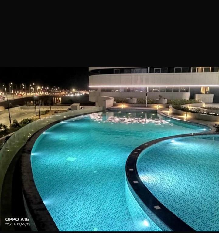a large swimming pool with blue water at night at Studio Alamein towers in El Alamein
