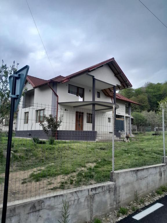 a white house with a fence in front of it at Casa Maria in Curtea de Argeş