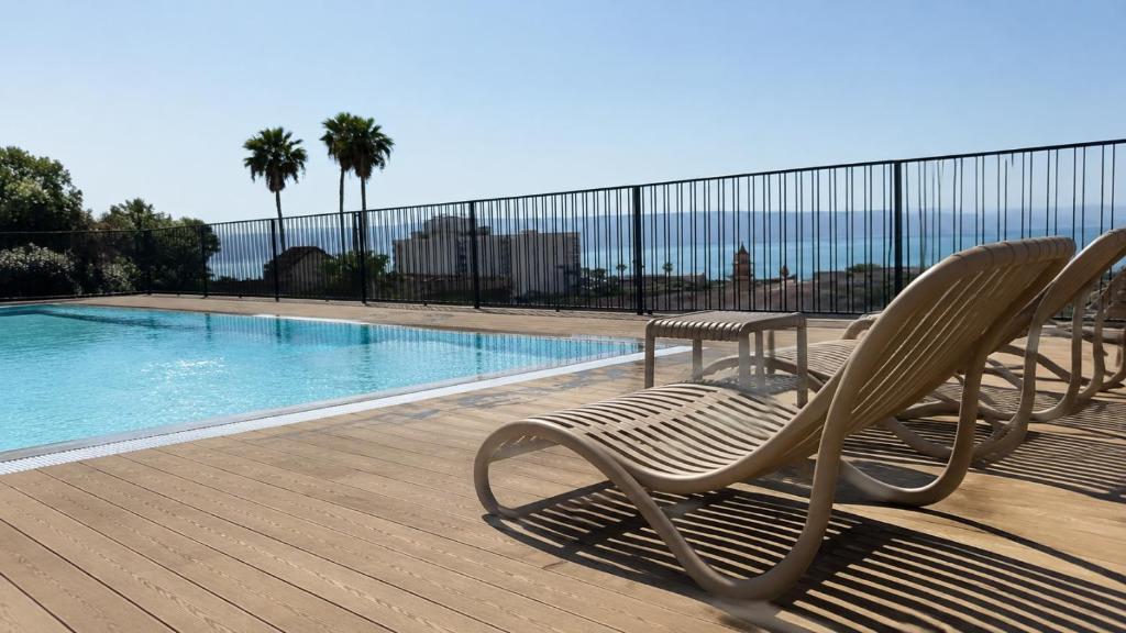 a pair of chairs sitting next to a swimming pool at Azura Boutique Hotel Tiberias in Tiberias