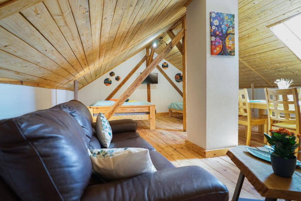 a leather couch in a living room with a wooden ceiling at Lawki Booking-Na Strychu in Ławki