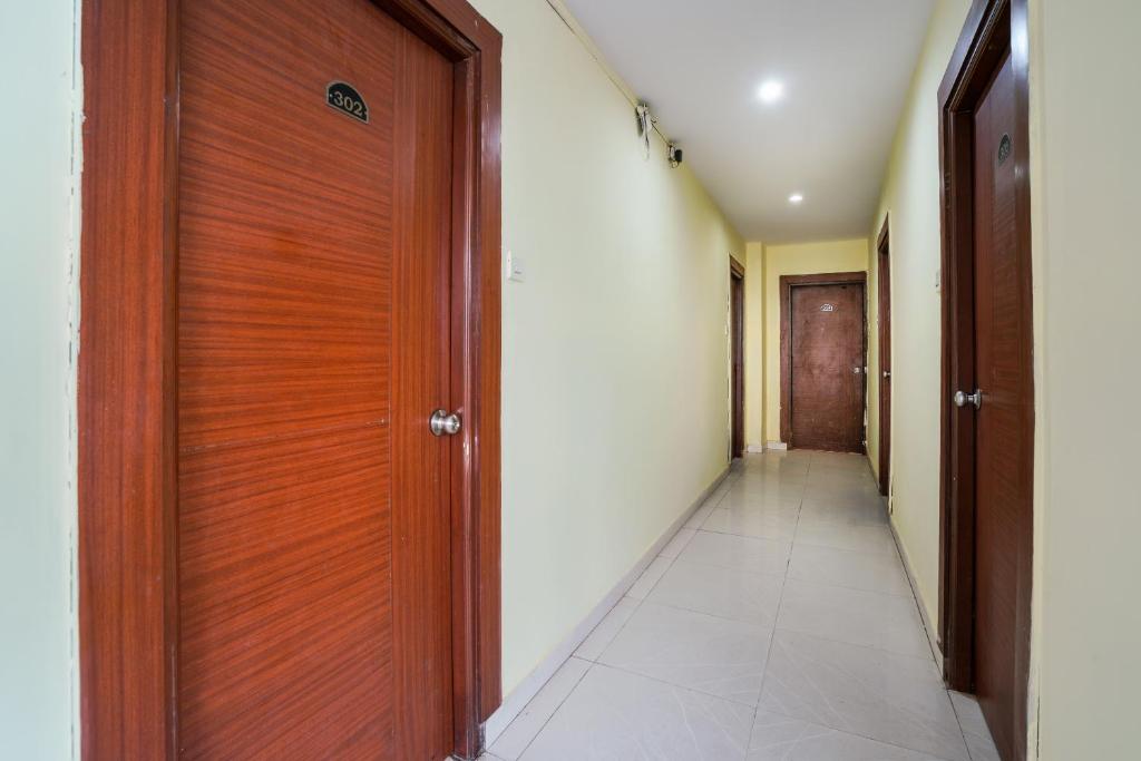a corridor with a wooden door in a hallway at Hotel O Pariwar Inn in Hyderabad
