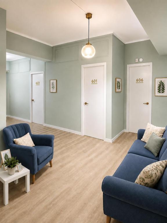 a living room with two blue couches and a table at Acropolis Center Rooms in Athens
