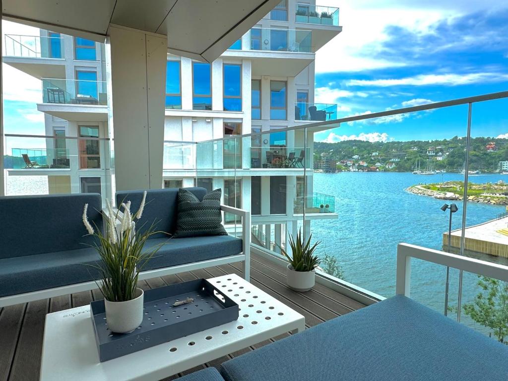 a balcony with a couch and a view of the water at Bryggebyen in Arendal