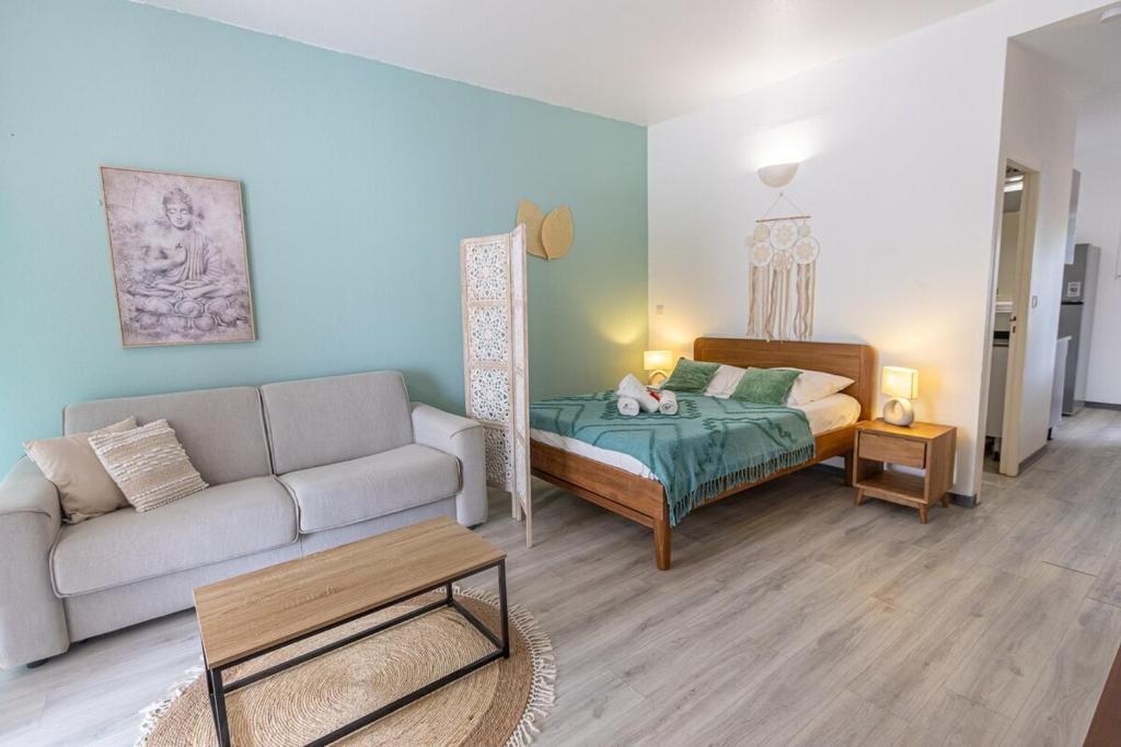 a living room with a couch and a bed at Studio équipé,Terrasse,Marina & plage à pied in Saint-François