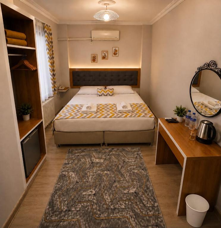 a small bedroom with a bed and a mirror at Kestanbol Hotel in Çanakkale