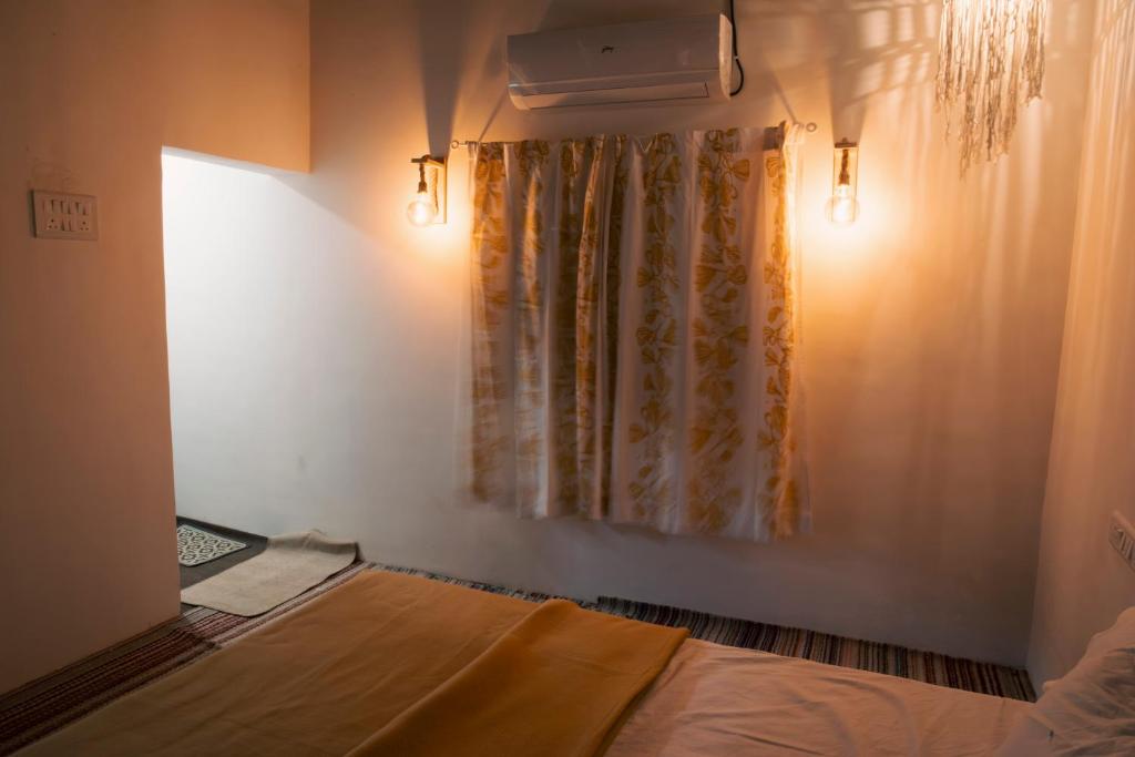 a bedroom with a bed and a curtain and lights at Jambhul Nest studio Pool & Rainforest Escape in Dhamni