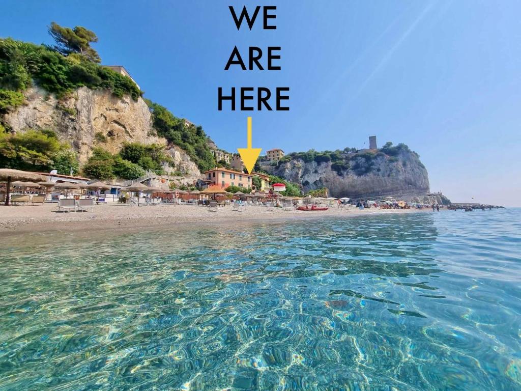 a picture of a beach with the words we are here at Affacciati al mare in Finale Ligure