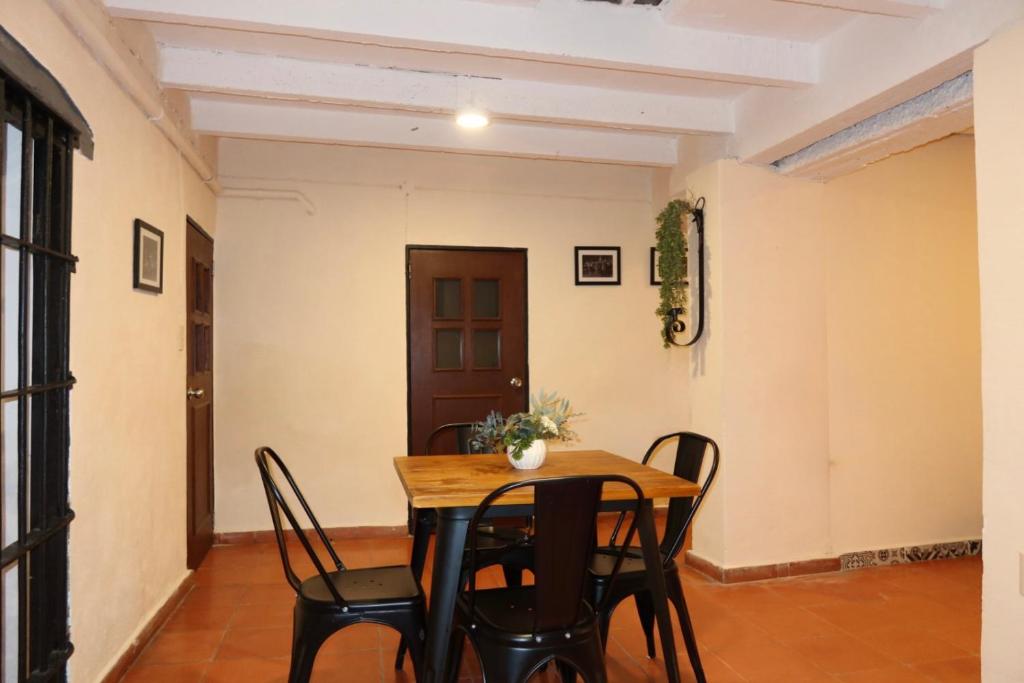 a dining room with a wooden table and chairs at Escondite de Galarza 26 in Guanajuato