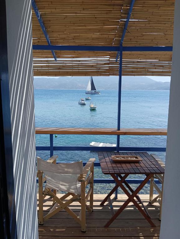 a table and chair on a porch with a view of the ocean at On The Waves Balcony in Klima