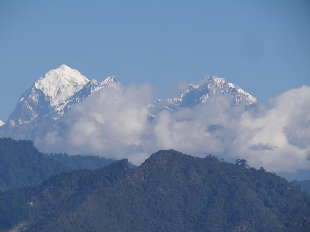 a snow covered mountain with clouds in front of it at Prathmesh Homestay in Bijanbāri Bāzār