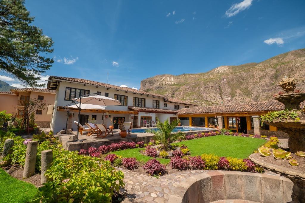 an exterior view of a house with a garden at Hotel San Agustin Urubamba in Urubamba