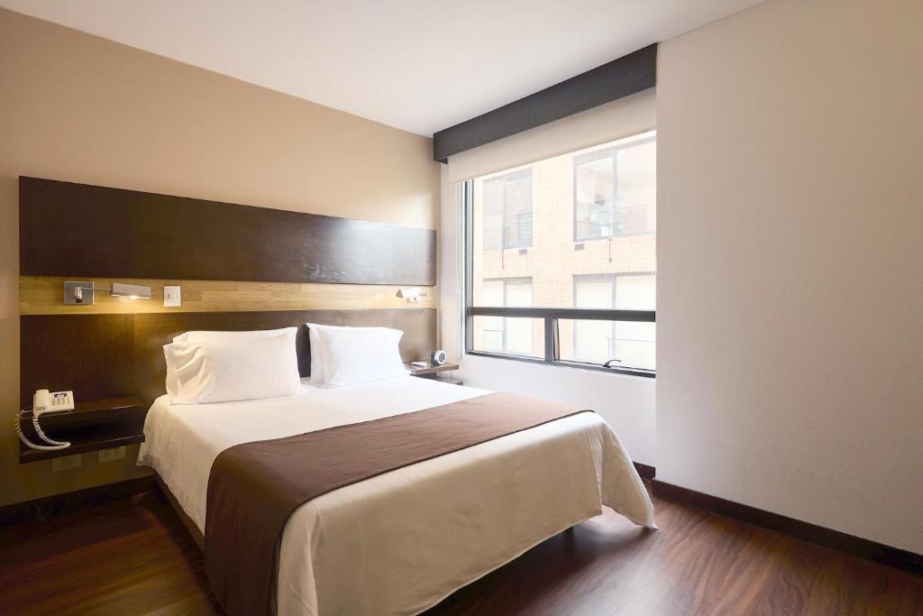a hotel room with a large bed and a window at Mercure Bogota BH Retiro in Bogotá