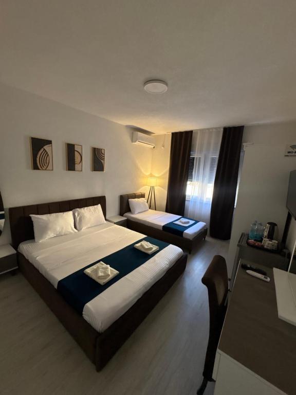 a hotel room with a bed and a desk at Hotel AKSA in Prizren