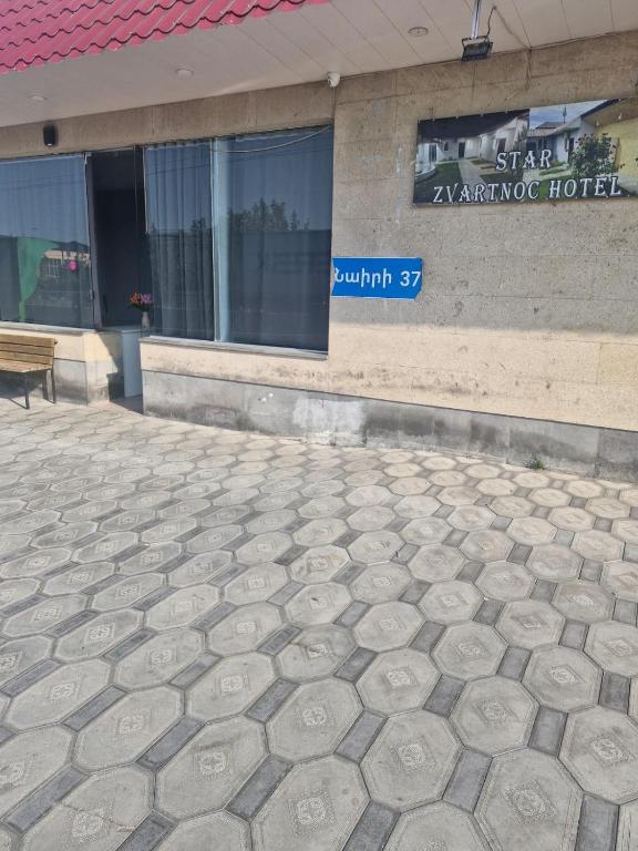 a stone sidewalk in front of a building at Zvartnoc siti star in Pʼarakʼar