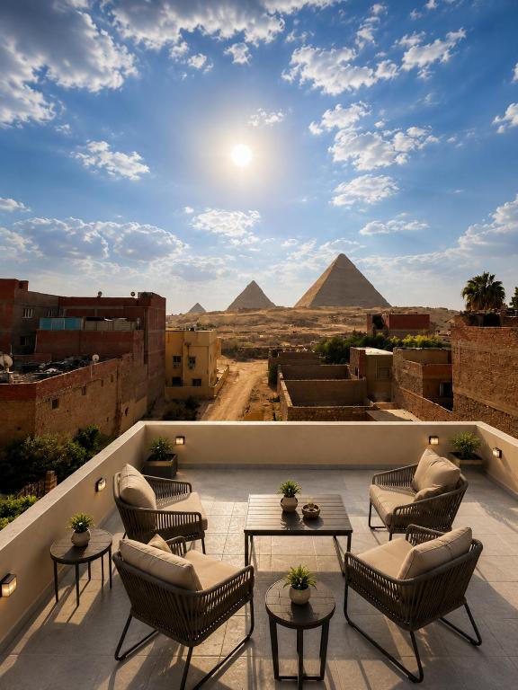 a view of the pyramids from a balcony with chairs and tables at Saqqara Pyramids view Hotel in Cairo