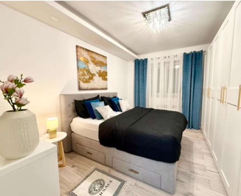 a bedroom with a large bed with blue curtains at Apartment "Mimoza 1" self check-in, self check-out in Otočac