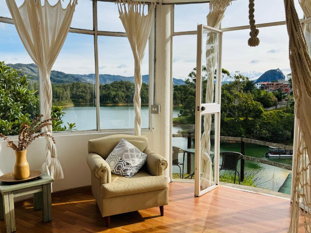 a living room with a chair and a large window at La Madriguera in Guatapé
