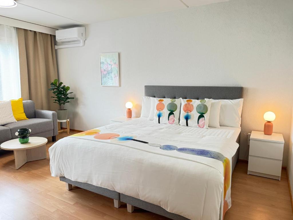 ein Schlafzimmer mit einem großen weißen Bett und Kissen in der Unterkunft Mon Koti in Turku
