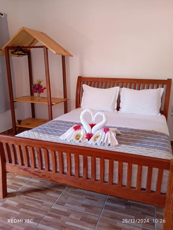 a bedroom with a bed with bows on it at Pousada Nativ0s in Baía Formosa