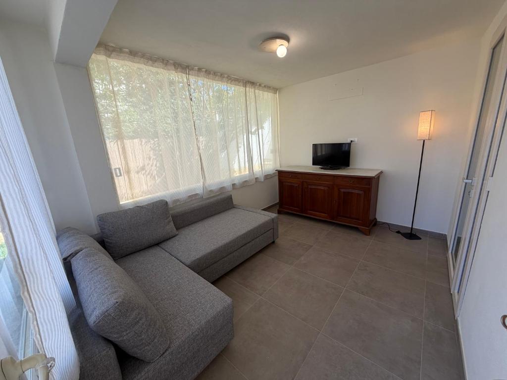 a living room with a couch and a television at Casa Arianna in Lido di Camaiore