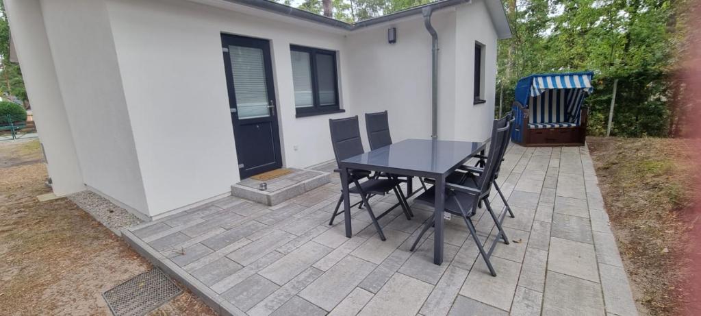 a table and chairs on a patio outside of a house at Ferienhaus Wellenklang in Glowe