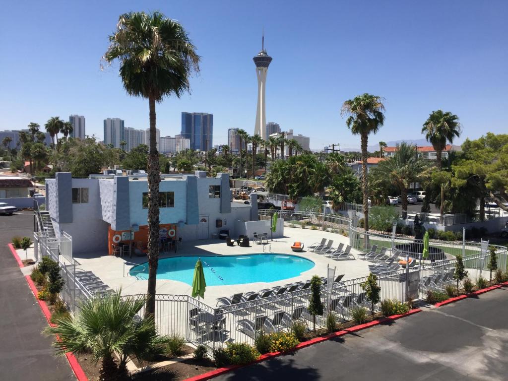 Blick auf einen Pool mit Palmen und ein Gebäude in der Unterkunft Thunderbird Boutique Hotel in Las Vegas