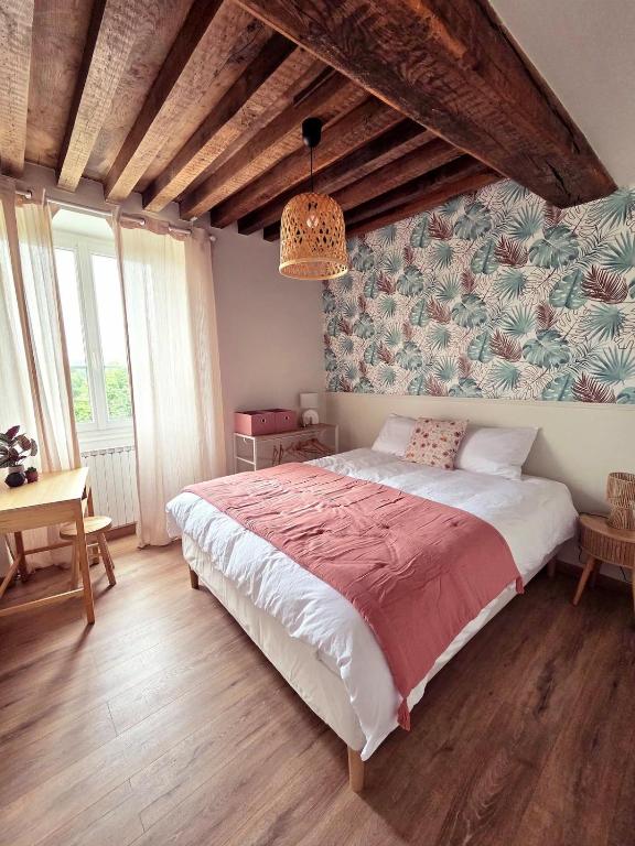 a bedroom with a large bed with a red blanket at L'écrin d'Hélène in Lormes
