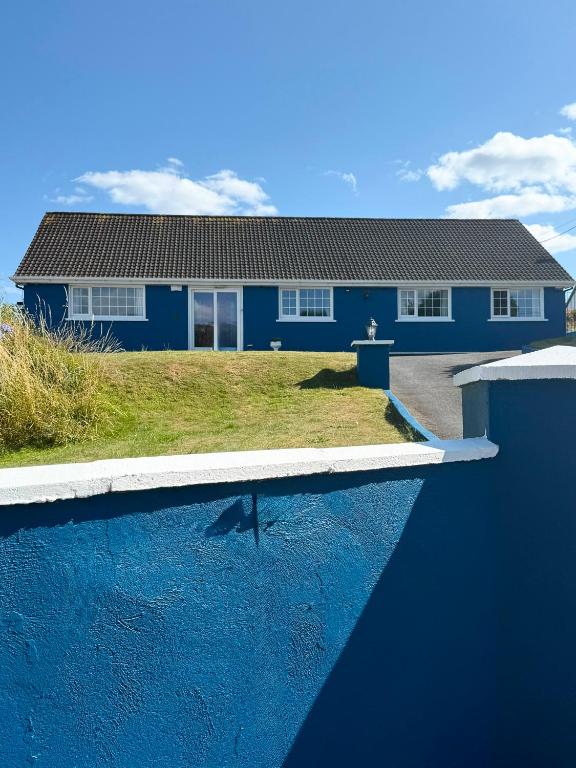 a blue house with a swimming pool in front of it at Ashgrove, Kinsale in Kinsale
