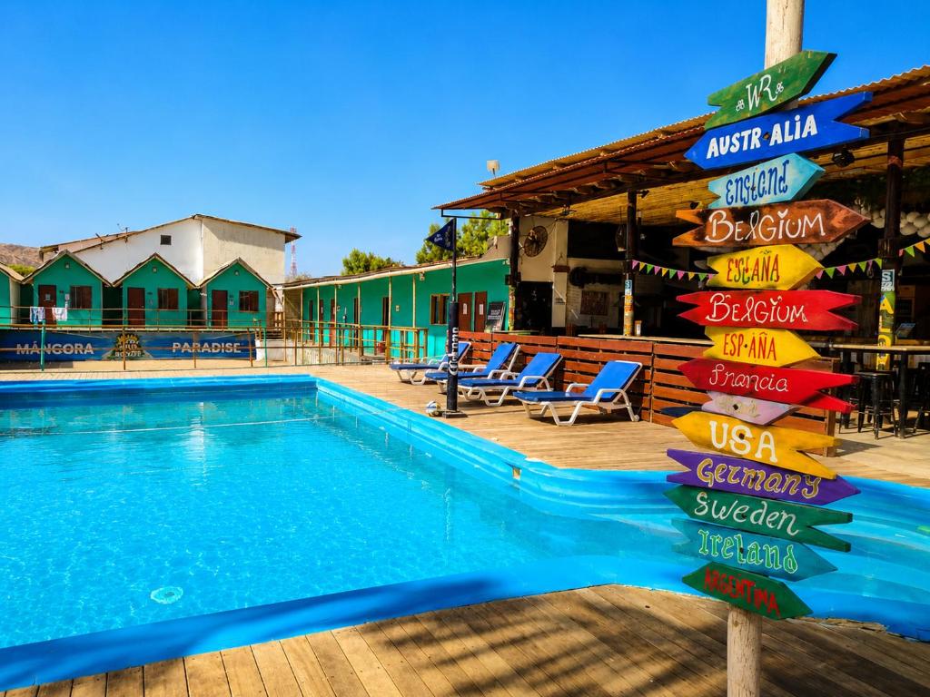 a sign that is next to a swimming pool at Wild Rover Beach Mancora in Máncora