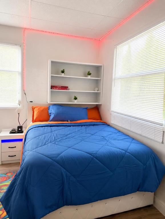 a bedroom with a blue bed and two windows at The orlando oasis in Orlando