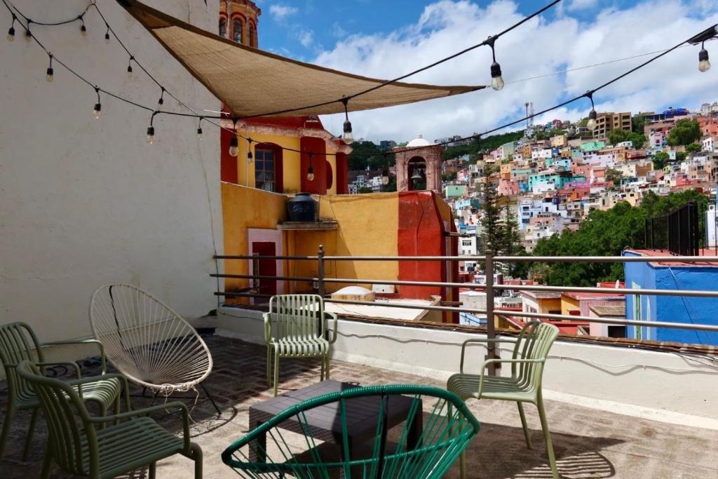 a balcony with chairs and tables and a view of a city at Balcones de Galarza 24 in Guanajuato