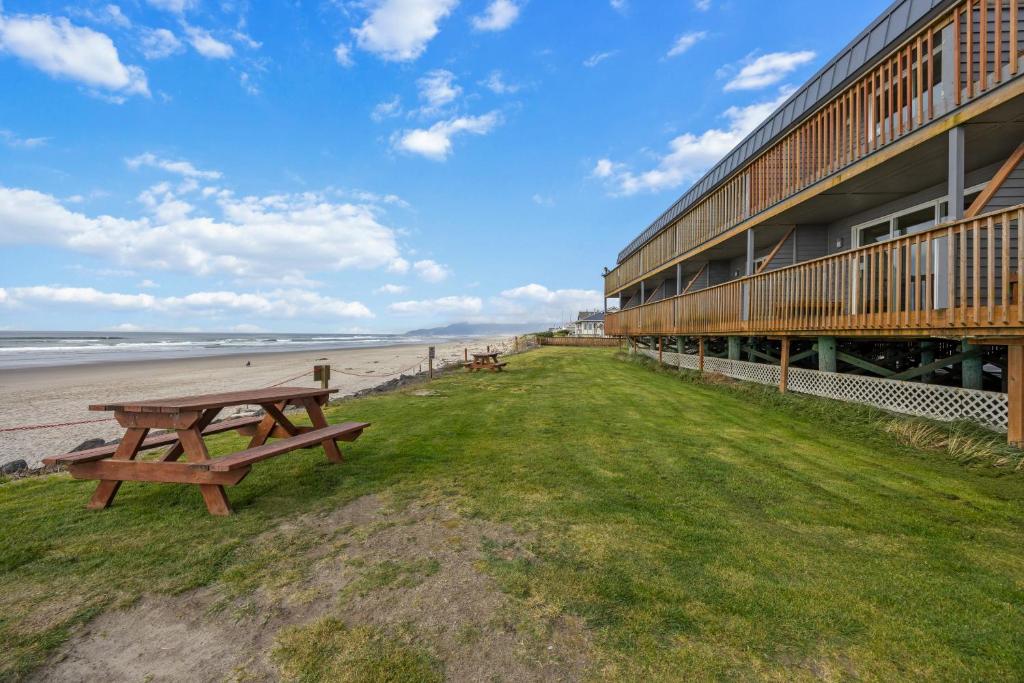 a picnic table on the beach next to a building at Surfside Resort in Rockaway Beach