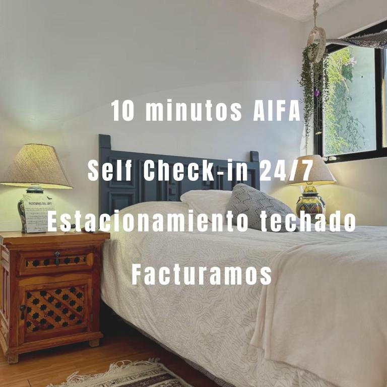 a bedroom with a bed and a table with a lamp at Beautiful Loft 10 minutes from AIFA in San Pedro Atzompa
