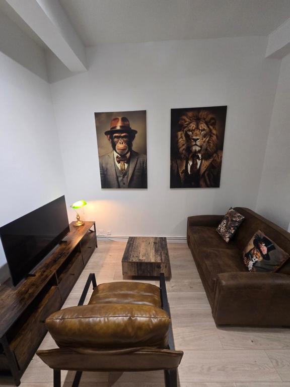 a living room with two couches and a tv at Le Club Philibert in Auxerre